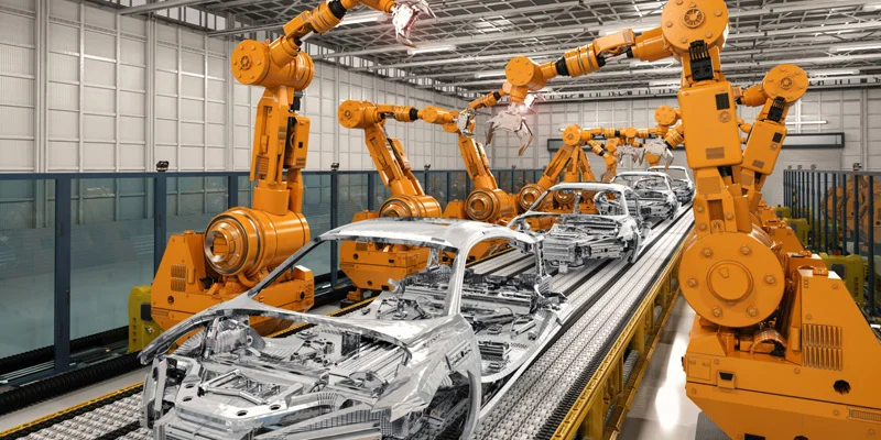 Robotic arms working on a vehicle assembly line in a factory